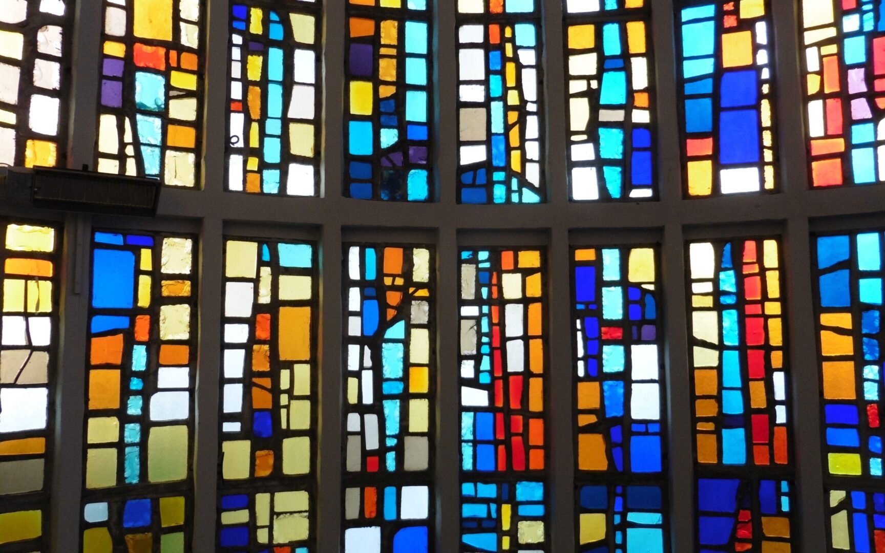 A stained glass window with many colors of different shapes and sizes.