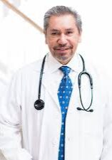 A man in white lab coat and blue tie